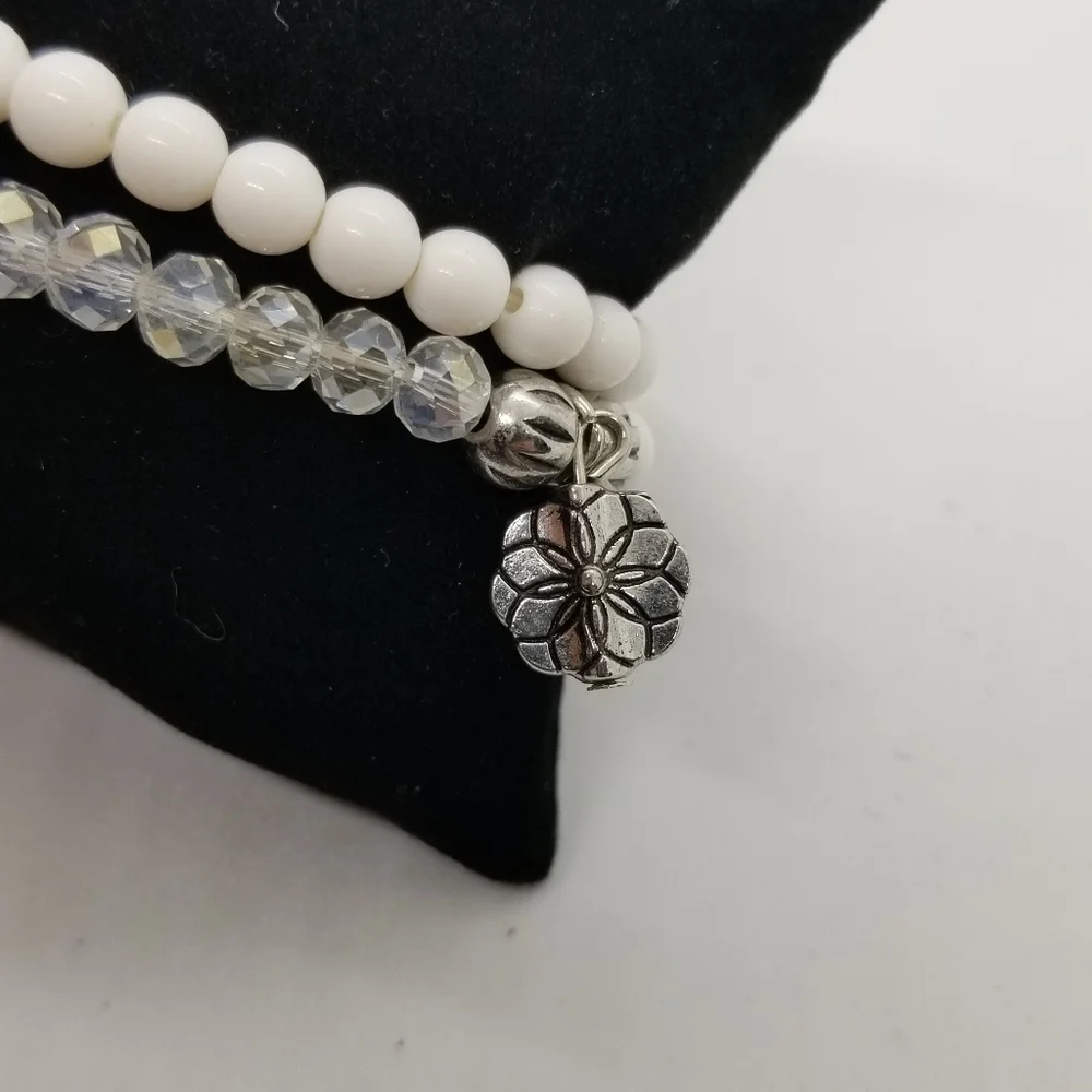 pair of white and clear stretch bracelets with shell charms